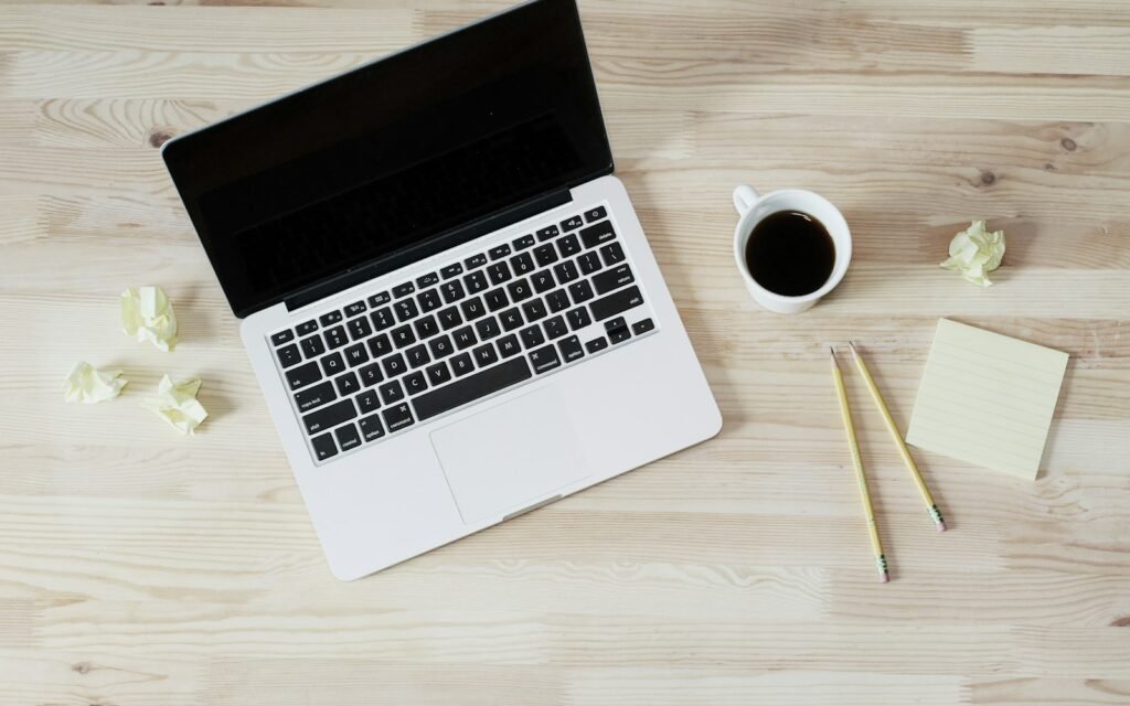 Turned off MacBook Pro beside white ceramic mug filled with coffee