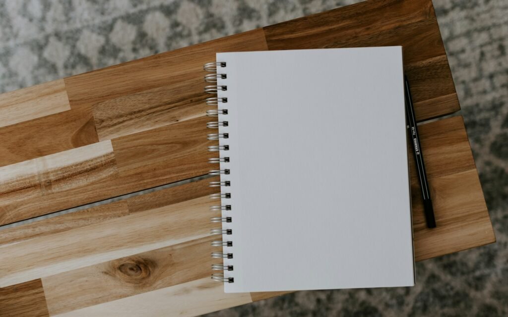 White spiral notebook on brown wooden table