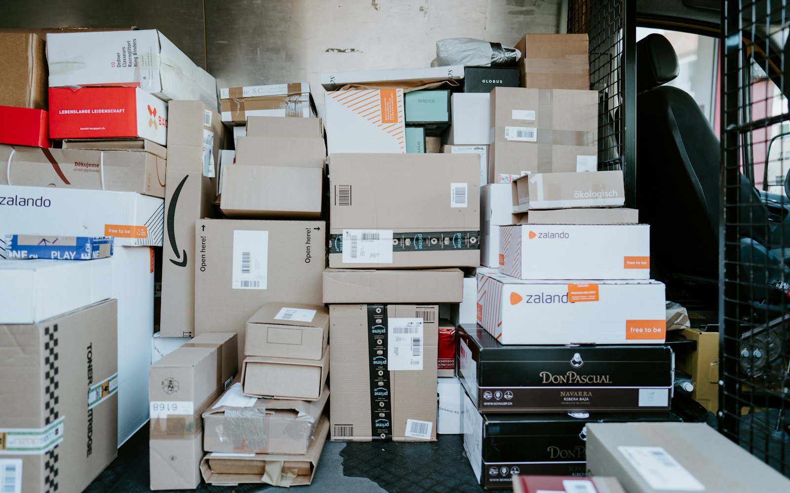 A stack of cardboard shipping boxes inside the back of a delivery van