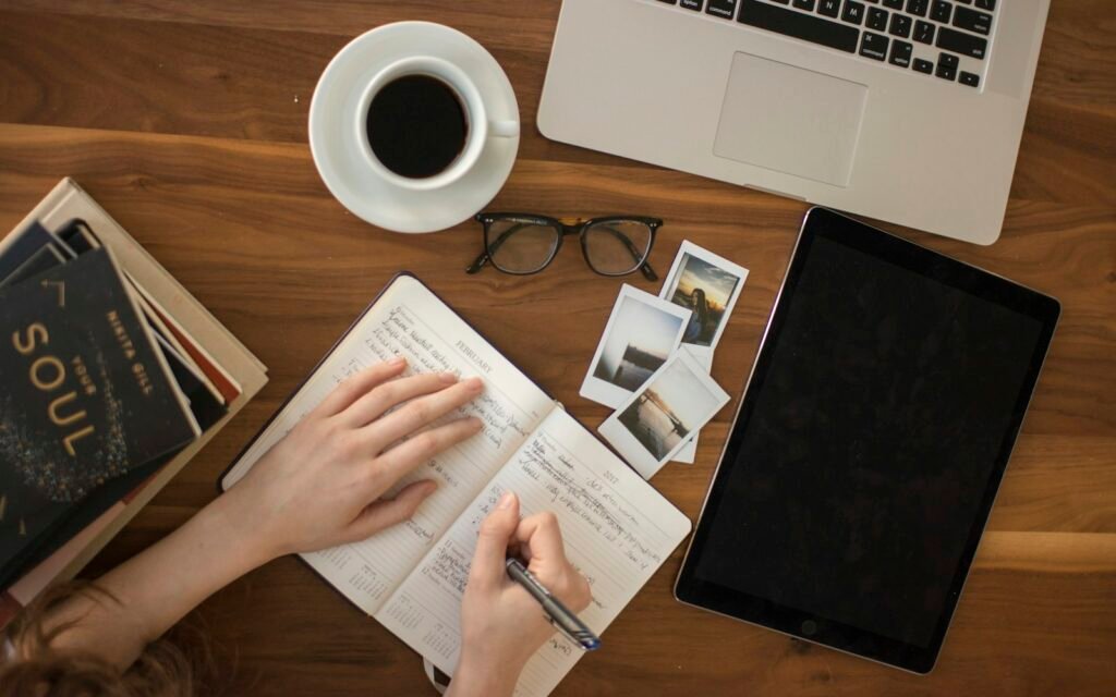 Person holding ballpoint pen writing on notebook