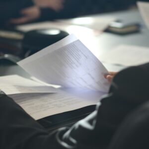 A woman sitting at a table reading a paper