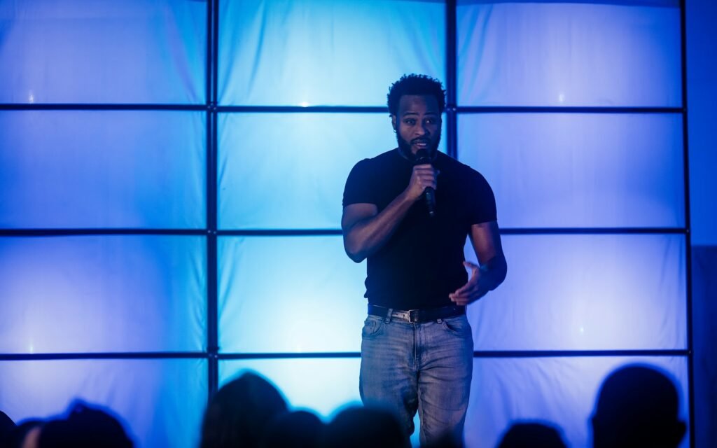 A man speaking into a microphone on a stage