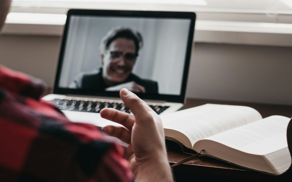 Person in red and black plaid long sleeve shirt using black laptop computer