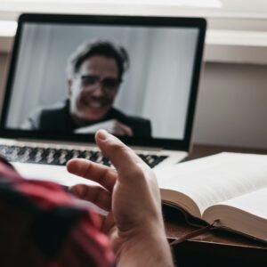 Person in red and black plaid long sleeve shirt using black laptop computer