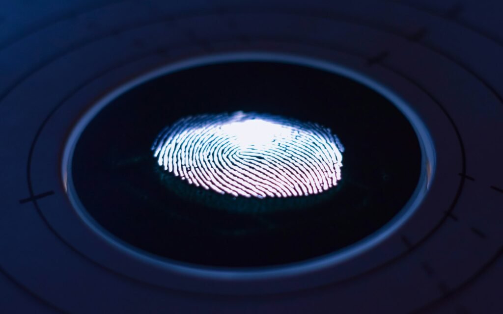 A glowing fingerprint on a dark circular scanner surface with concentric lines